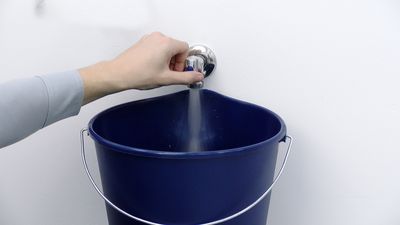 Aprire il rubinetto dell’acqua della lavatrice con un secchio sotto