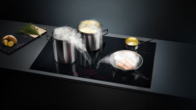 InductionAir Plus hob with pans and ingredients surrounding it