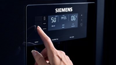 Siemens: En hånd trykker på Super Freeze-alternativet på kjøleskapets display