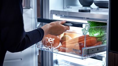 Siemens; Eine Person stellt eine hyperFresh-Box in den Kühlschrank oder nimmt sie heraus