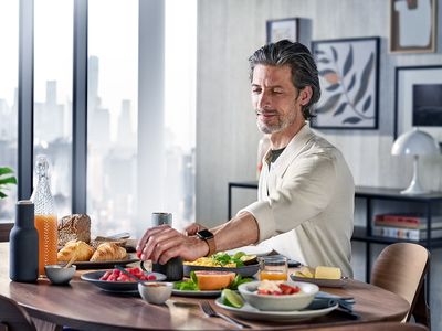 Siemens : un homme et une femme mangent un petit-déjeuner complet avec croissants, fruits frais et café