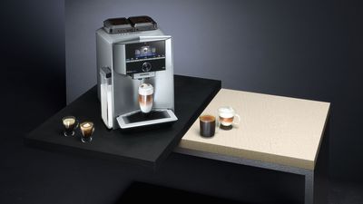 Siemens Kaffeewelt - Ein Siemens EQ.9 plus Kaffeevollautomat von vorn, mit verschiedenen Kaffeespezialitäten