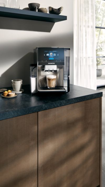 Siemens Vitvaror underhåll, rengöring och skötsel av kaffemaskiner i EQ-modellsortimentet inkl. kvinna som smuttar kaffe