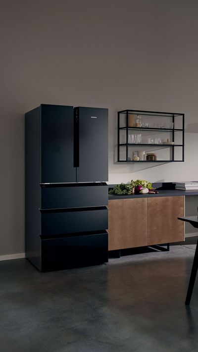 Es ist eine moderne Holzküche zu sehen, die mit leistungsstarken Siemens Hausgeräten ausgestattet ist.