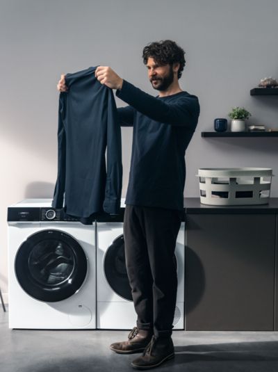 mand kigger på vasketøj