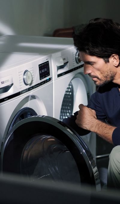 Hållbart kök - bild på man som laddar tvättmaskin