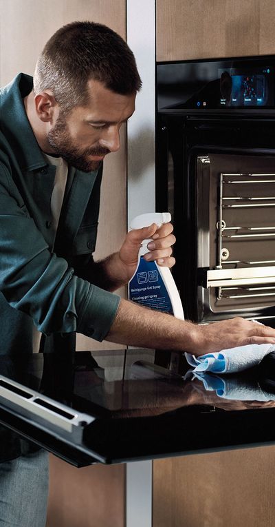 Mężczyzna stosujący produkt Siemens do czyszczenia piekarnika