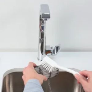 Sciacquare il filtro della lavastoviglie sotto l’acqua corrente