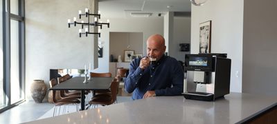 Richard Juhlin holder en kop kaffe ved siden af en espressomaskine fra Siemens
