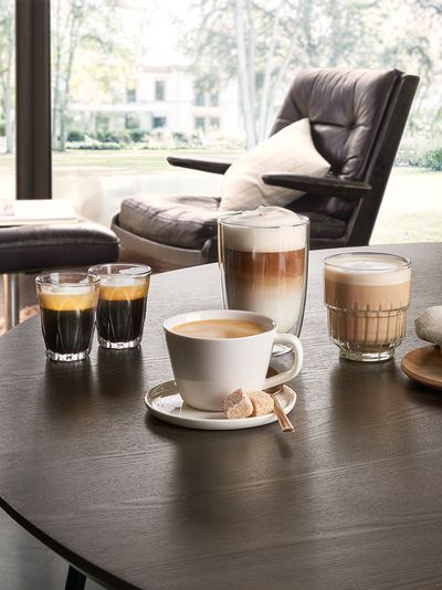 forskellige kaffedrikke på et bord i smukke glas og kopper