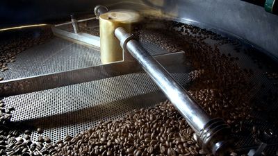 Kaffebönor som rostas i en trumrost