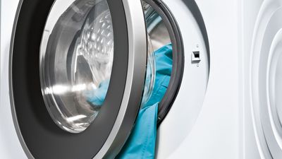 Siemens Vitvaror öppen tvättmaskin med kläder hängande ut från luckan