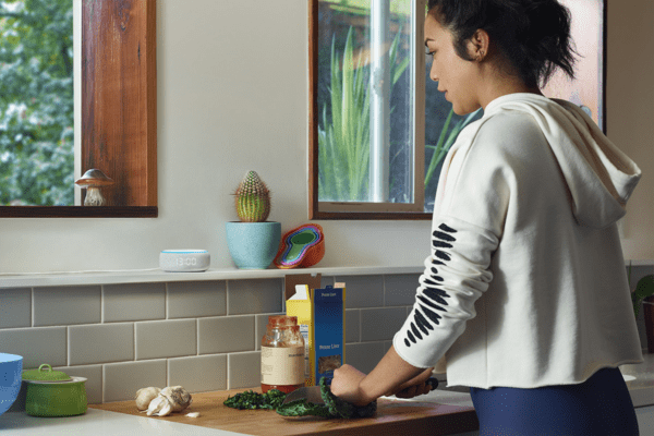 Mladá žena skladá bielizeň na práčke s Home Connect.
