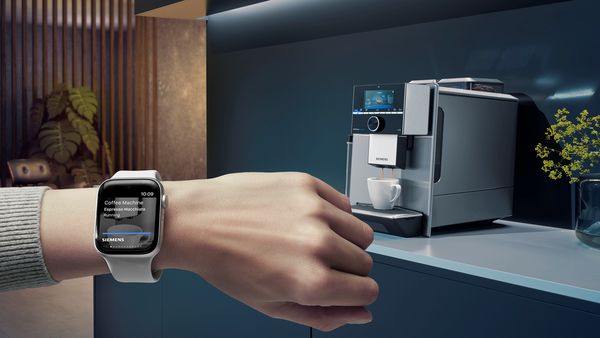 Hand mit Apple Watch am Handgelenk, Screen zeigt Kaffee Favoriten. Küche mit Siemens Hausgeräten im Hintergrund.