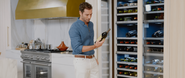 Homme prenant une bouteille de vin d'un réfrigérateur de vin Thermador