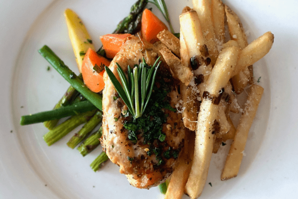 Plate of chicken french fries carrots and asparagus