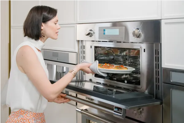 thermador built in speed oven door open woman taking pizza out
