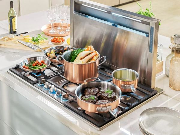 copper pots on gas cooktop with downdraft