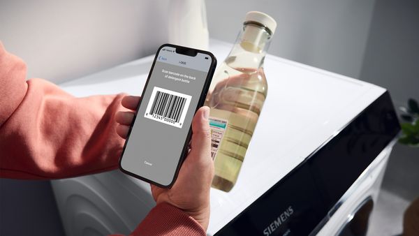 Eine Person scant mit dem Smartphone den Barcode einer Waschmittel-Flasche. Es zeigt die Home Connect Funktion i-Dos mit Waschmittel-Scan.
