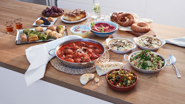 Ξύλινος πάγκος κουζίνας με πολλά διαφοετικά μαγειρεμένα φαγητά.