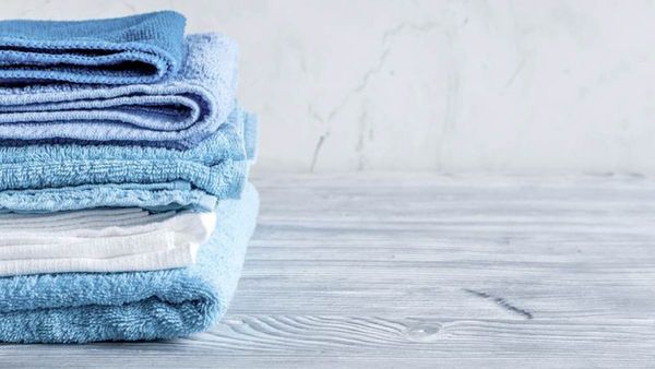 Διπλωμένες πετσέτες σε μπλέ αποχρώσεις πάνω σε ξύλινο τραπέζι.