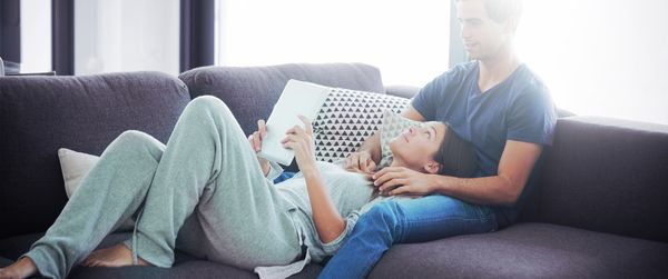 Pora ant sofos naudoja „Home Connect“ programėlę.