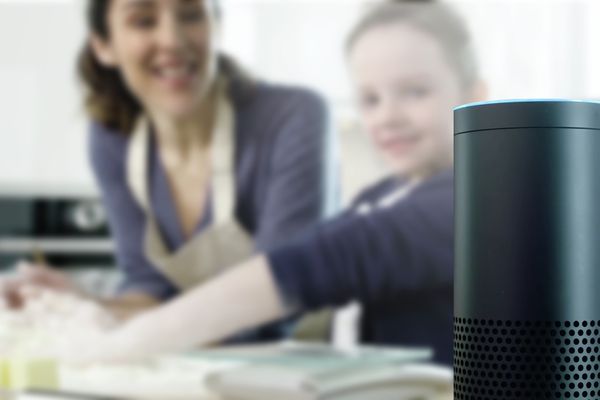 Vaikas su mama gamina valgį ir duoda „Alexa“ balso komandą, kad „Home Connect“ orkaitė įkaistų.