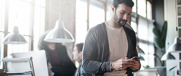 Mann bedient die Home Connect App im Büro
