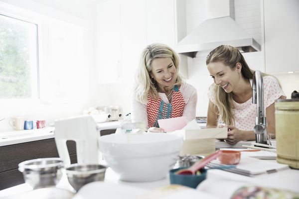 Zwei Freundinnen sitzen in der Küche und backen. Alles geht enifacher, dank Home Connect.