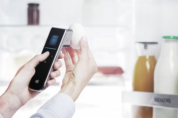 A woman scanning an egg with X-Spect from Home Connect