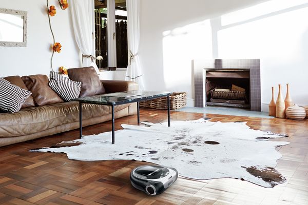 A Home Connect robot vacuum cleaner vacuuming a living room