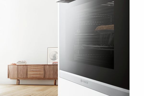 Sicht von einem Home-Connect-fähigen Backofen auf ein Wohnzimmer