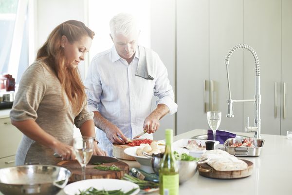 An elderly married couple are getting to know the Home Connect functions and making the most of them whilst cooking