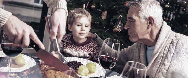 Großvater und Enkel am Tisch beim Braten Essen