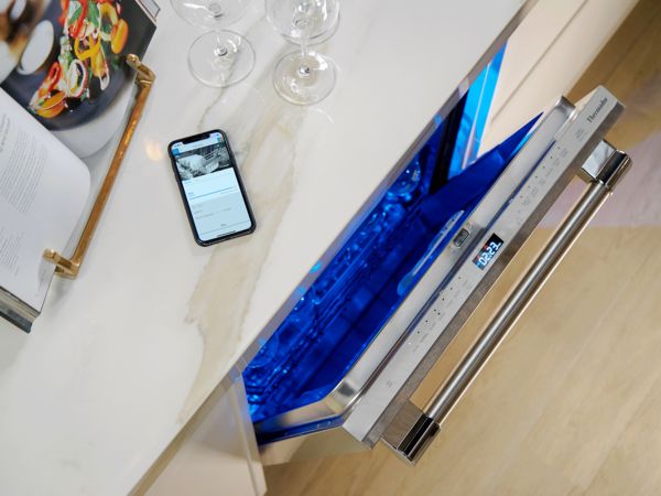 Thermador Connect Experience shown in smart device next to dishwasher