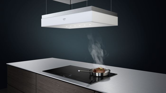 Island cooking on induction hob with hood extractor directly above