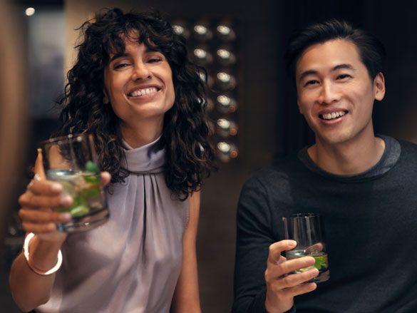 Uomo e donna sorridenti con un drink in mano