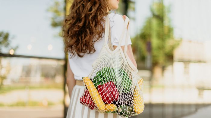 Person carrying groceries in netted bag