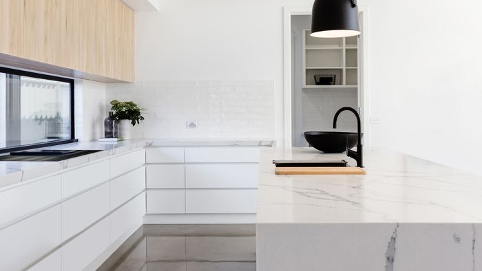 Spacious white kitchen with large island in centre