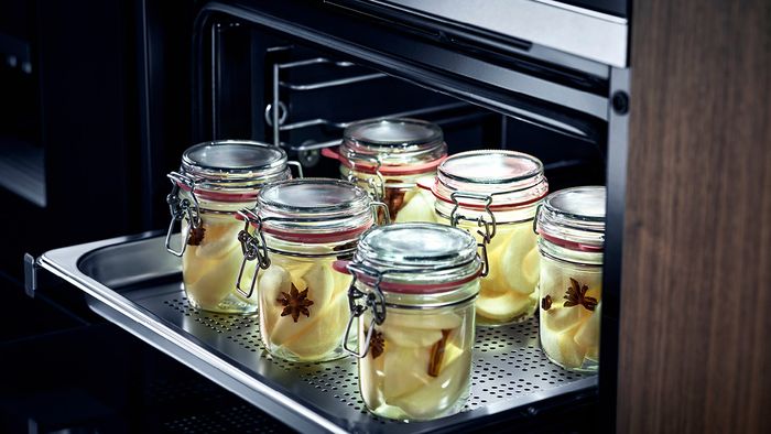 Multiple jars with food in sat on oven shelf