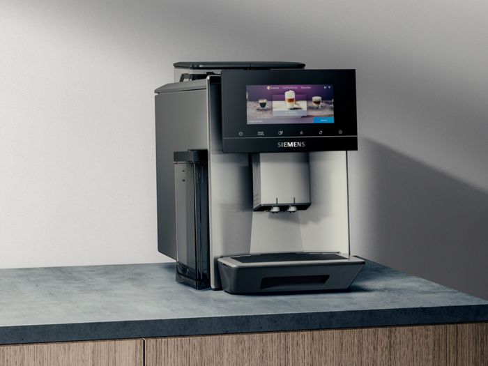 Elegantní kávovar Siemens s dotykovým displejem umístěný na moderní kuchyňské lince.