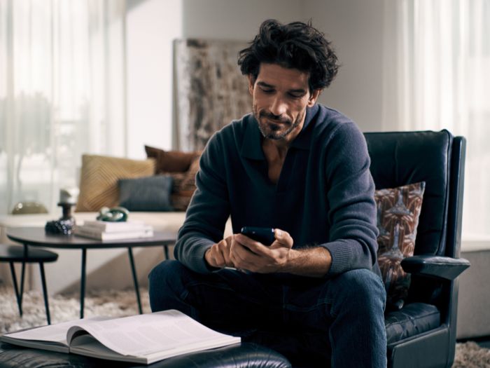 Giovane uomo inserisce nell’app gli ingredienti del frigorifero