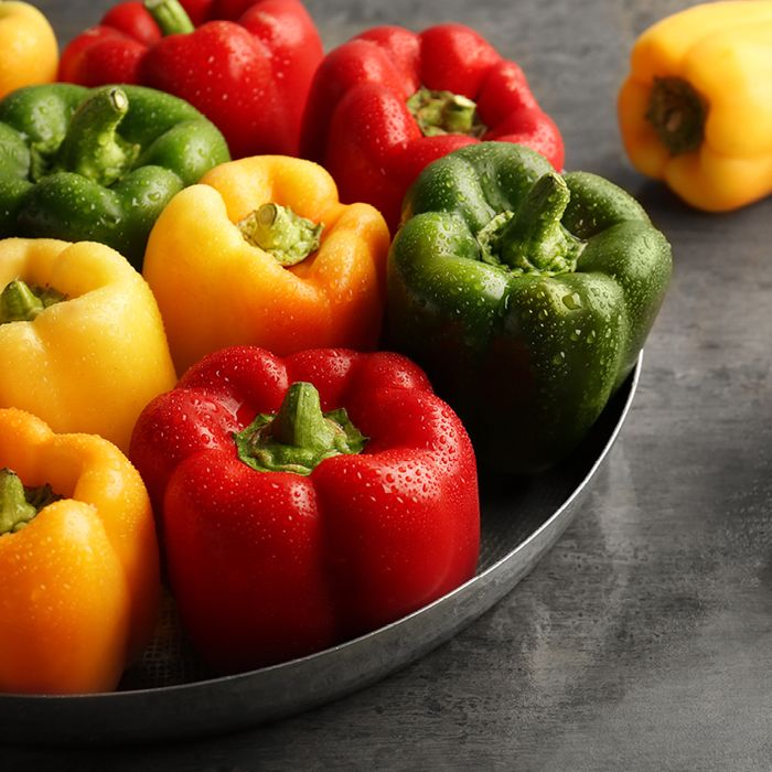 Red, green and yellow peppers in a bowl.