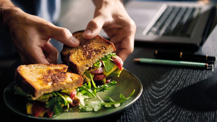 Person picking grilled sandwich up from plate