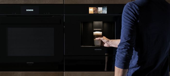 Macchina da caffè da incasso Siemens con uomo che estrae una bevanda appena preparata