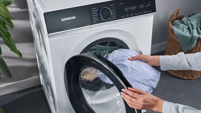  Wäsche wird zum Waschen in eine Siemens Frontlader-Waschmaschine gegeben.