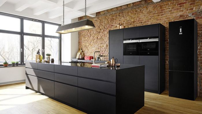 Los electrodomésticos de acero inoxidable aportan brillo en una cocina negra.