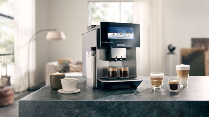 Siemens coffee machine on a kitchen counter with various full coffee mugs