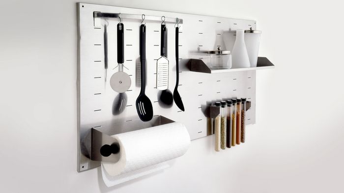 Utensili da cucina disposti in un supporto a parete ben organizzato
