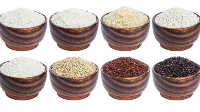 Conjunto de diferentes tipos de arroz en tazones de madera: blanco, marrón, bajomati, salvaje, jazmín, rojo, negro.